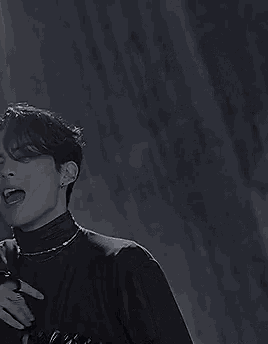 a black and white photo of a young man wearing a turtleneck