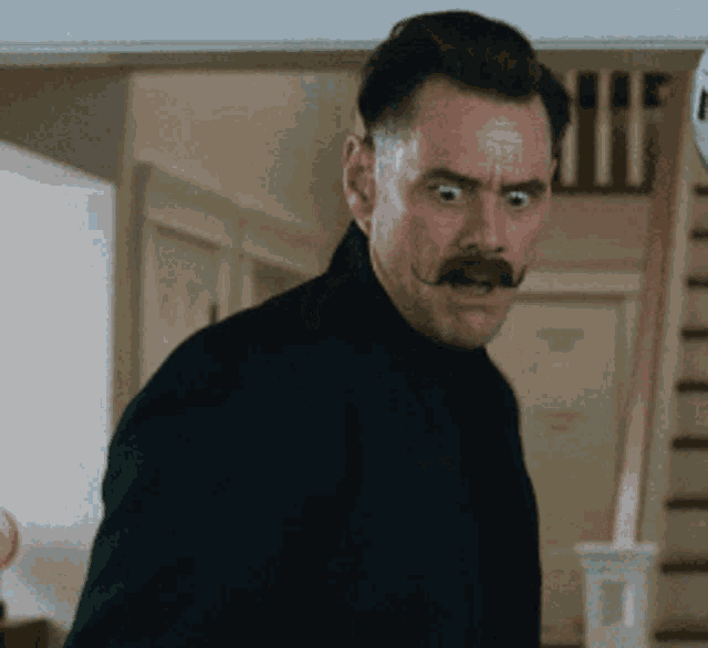 a man with a mustache is making a face