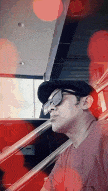 a man wearing a hat and sunglasses is sitting on a set of stairs