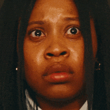 a close up of a woman 's face with a tear running down her cheek
