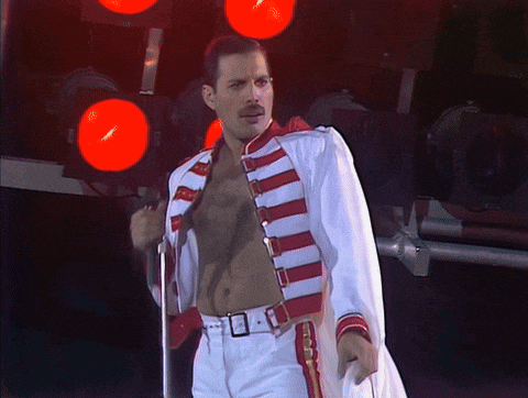 a man in a white and red striped jacket stands in front of a red light