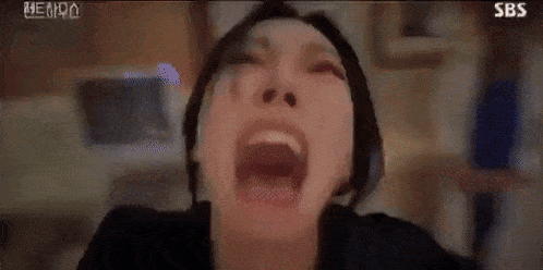 a close up of a woman 's face with her mouth open in a room .