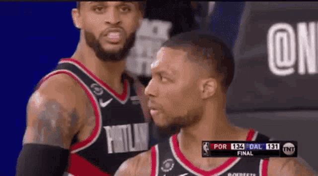 two basketball players are standing next to each other in a basketball game .