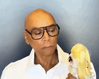 a man wearing glasses and a white shirt is holding a stuffed animal .
