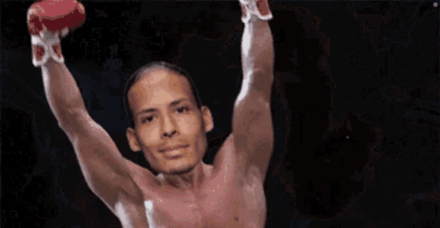 a shirtless man is holding his arms in the air .