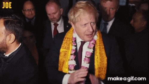 a man in a suit and tie wearing a yellow scarf around his neck
