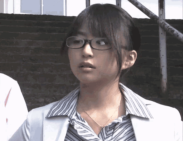 a young woman wearing glasses and a striped shirt