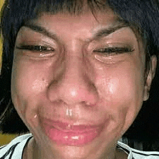 a close up of a woman 's face with a tear running down her nose .