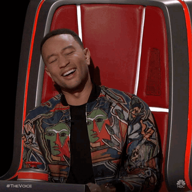 a man in a colorful jacket is sitting in a chair with his eyes closed and smiling