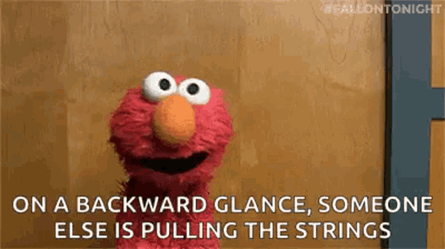 elmo is pulling the strings on a backward glance .