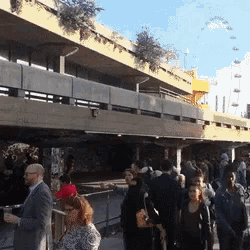 a group of people are standing under a bridge