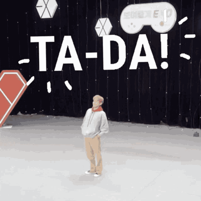 a person is standing in front of a sign that says ta-da