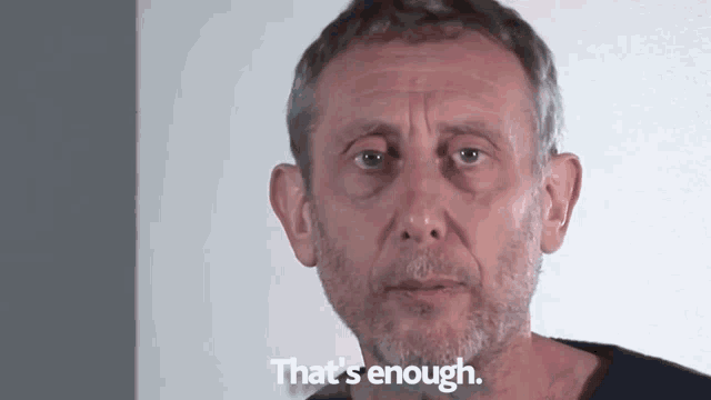 a man with a beard says that 's enough in front of a white wall