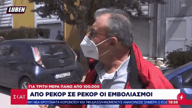 a man wearing a mask is being interviewed on a news channel