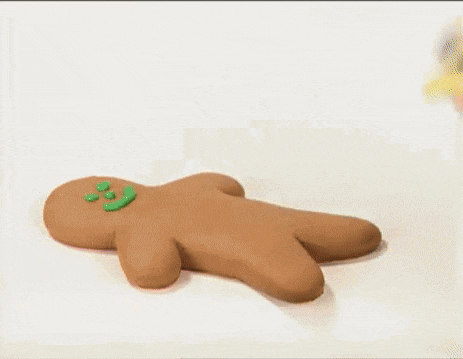a person is holding a stuffed animal shaped like a gingerbread man