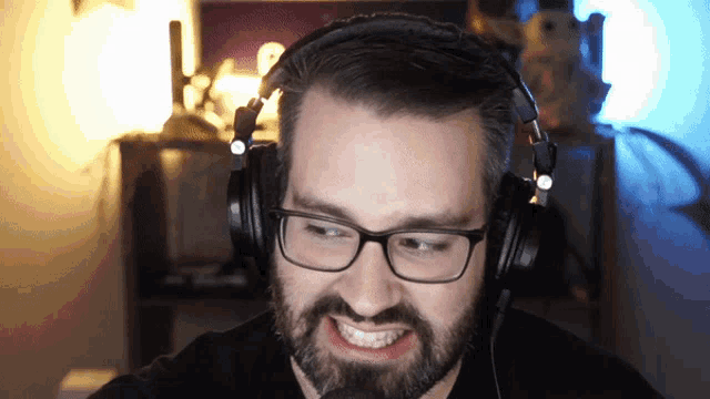 a man with glasses and headphones is smiling and looking at the camera