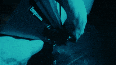 a person with a tattoo on their arm is holding a blue object that says bungee.com