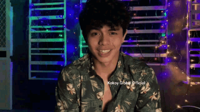 a young man wearing a green shirt that says kokoy global
