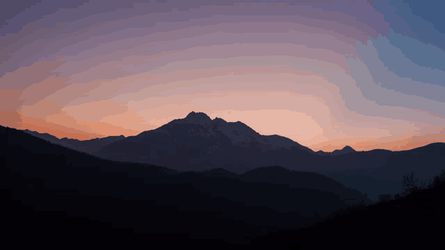 a sunset with mountains in the foreground