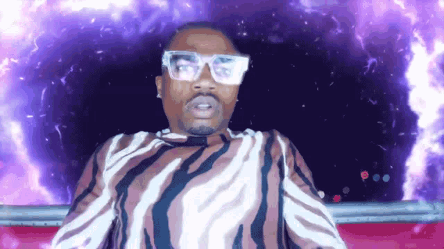 a man wearing glasses and a zebra print shirt looks at the camera
