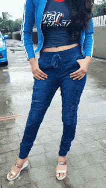 a woman wearing a blue jacket and a t-shirt that says just do it is standing in front of a blue car