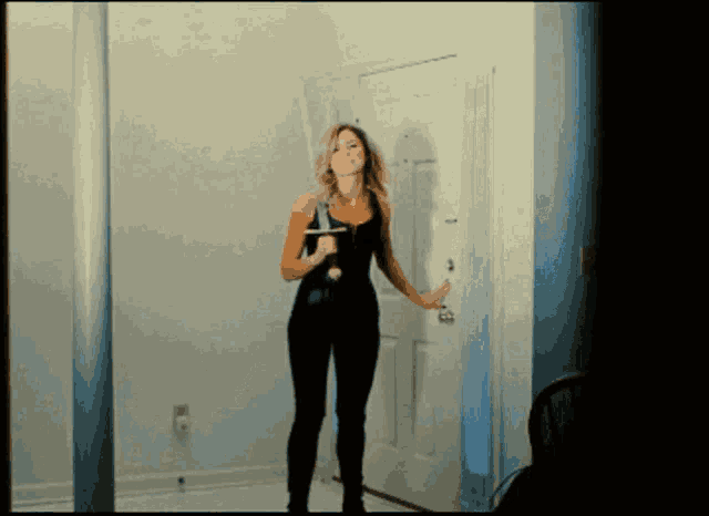 a woman standing in front of a door holding a sword
