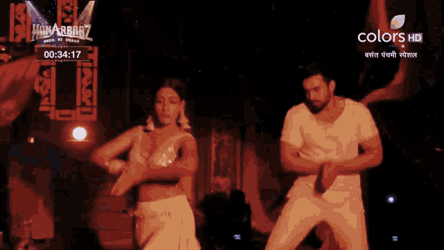 a man and a woman are dancing in front of a sign that reads colors hd