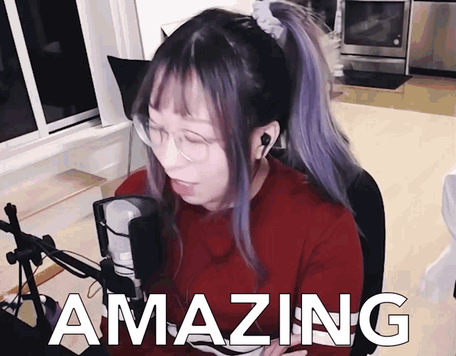 a woman with purple hair is sitting in front of a microphone and the word amazing is on the bottom