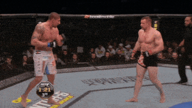 two men are fighting in a ufc ring with a boostmobile ad in the background