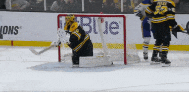 a hockey goalie is kneeling in front of a sign that says blue