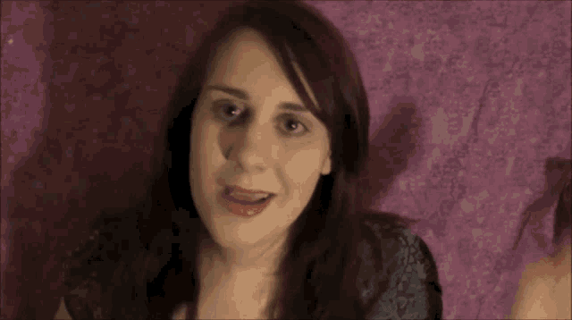 a close up of a woman 's face with purple background