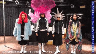 a group of women standing next to each other with one wearing a feathered hat