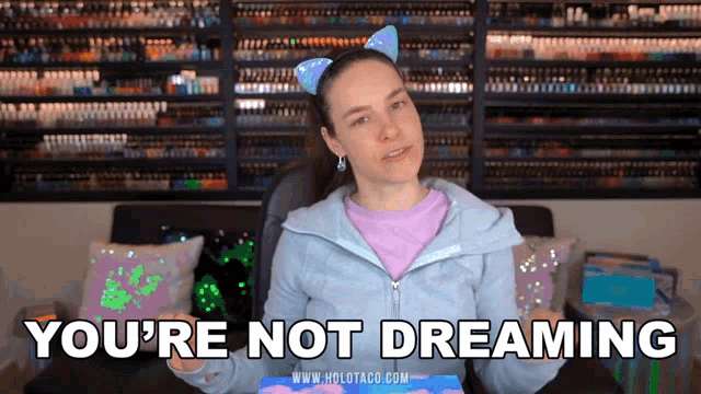 a woman in a cat ear headband is saying you 're not dreaming