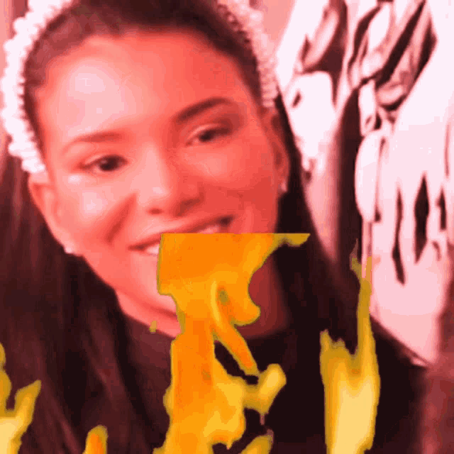 a woman with a pearl headband is smiling with a yellow flame coming out of her mouth