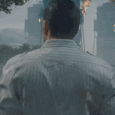 a man in a white shirt looks over his shoulder at something
