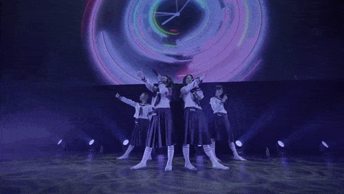 a group of girls singing in front of a large clock