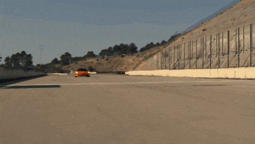 a blurred image of an orange car driving on a road