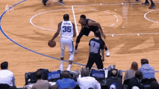a basketball player with the number 35 on his jersey dribbles the ball