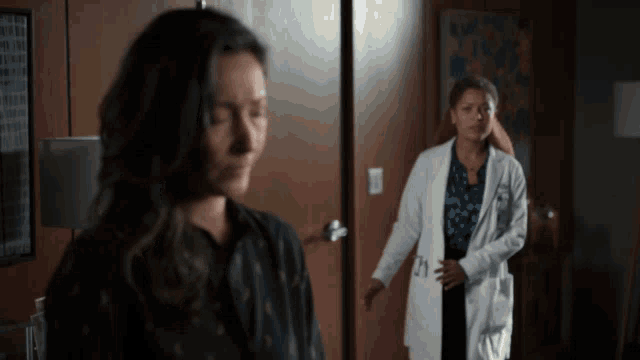 a woman in a lab coat with the number 21 on the pocket