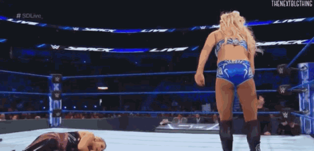 two women are wrestling in a wrestling ring with a referee watching .