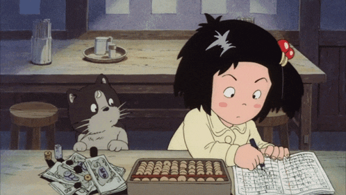 a girl is writing on a piece of paper while a cat sits behind her