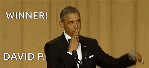 barack obama is giving a speech in front of a microphone while covering his mouth .