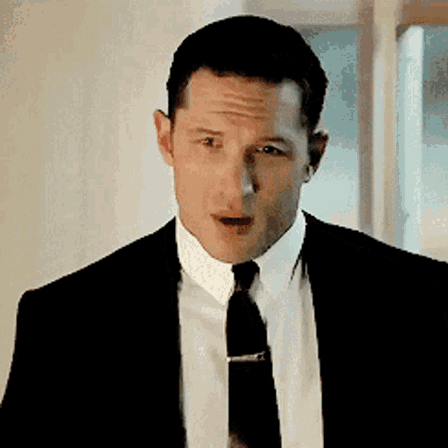a man in a suit and tie is making a surprised face