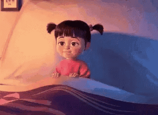 a little girl is sitting in a bed with a blanket .