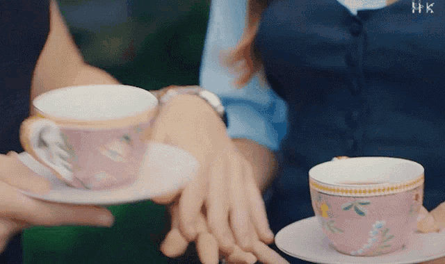 a couple holding hands while holding cups of coffee