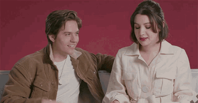 a man and a woman are sitting next to each other on a blue couch .