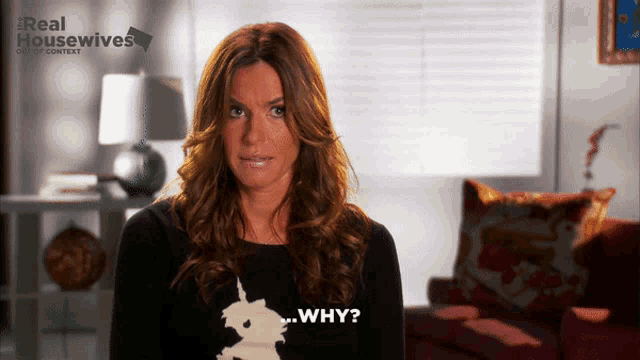 a woman wearing a black sweater with a unicorn on it says " why "