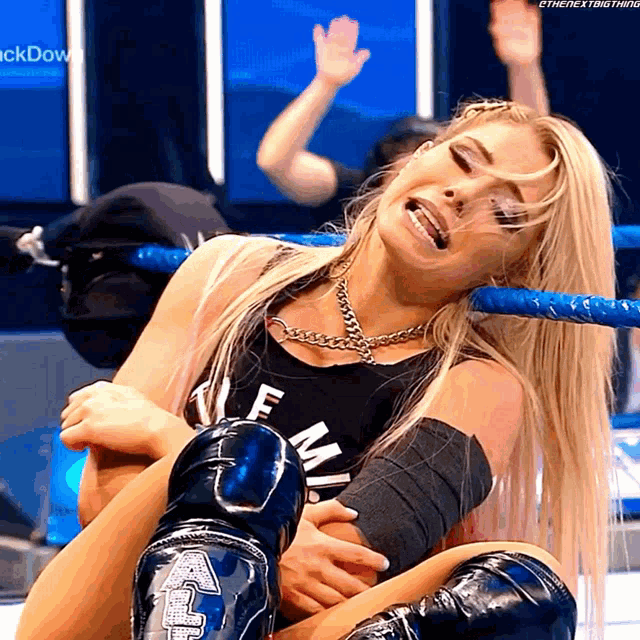 a woman in a wrestling ring with the word " the next thing " on the bottom right