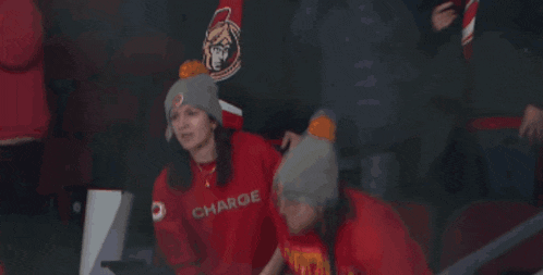 two women wearing red shirts with the word charge on it