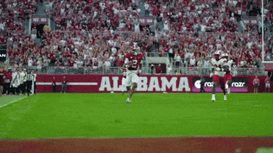 a football game is being played in front of a large alabama banner